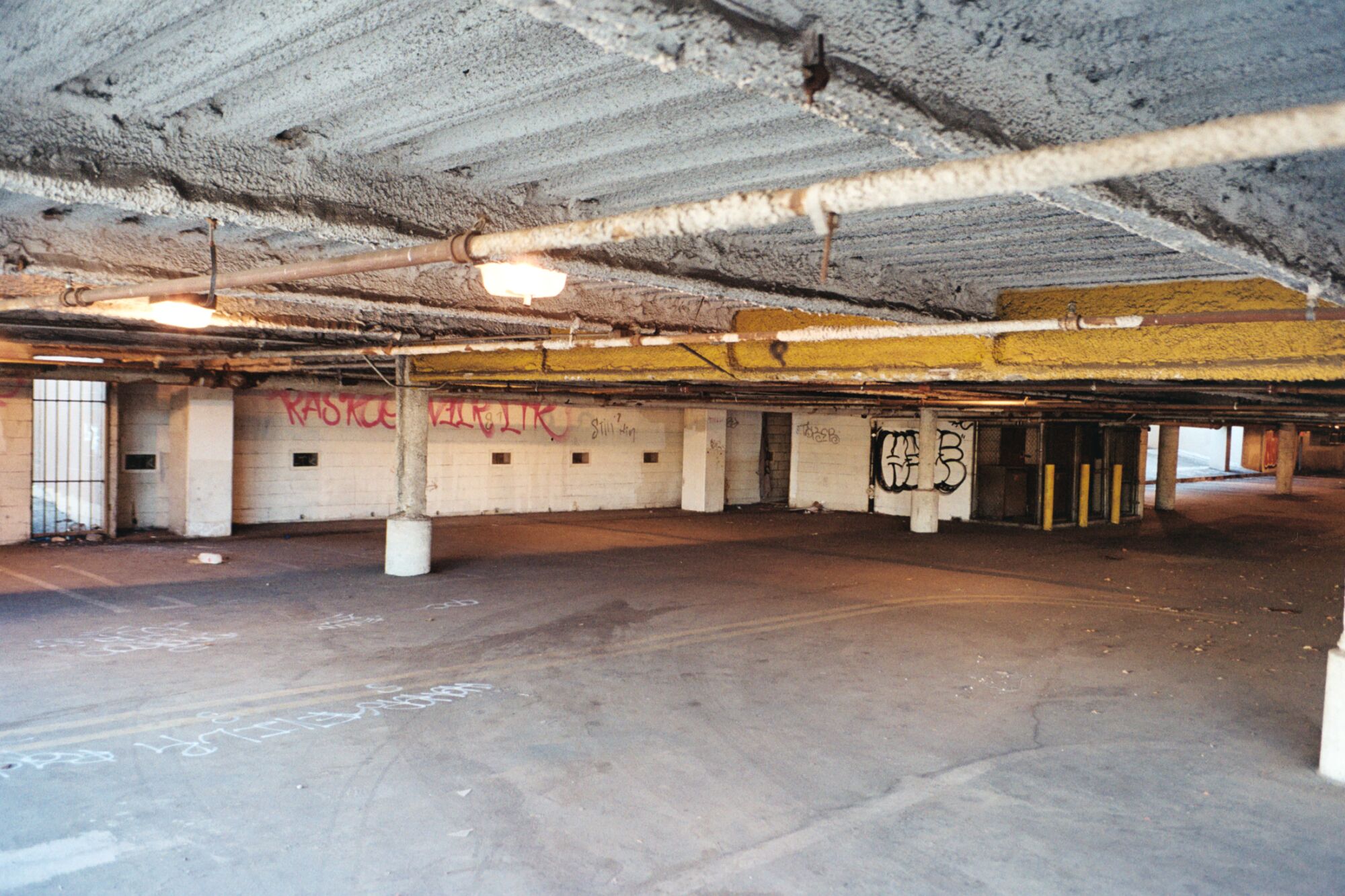 The interior of an empty garage with graffiti on the walls