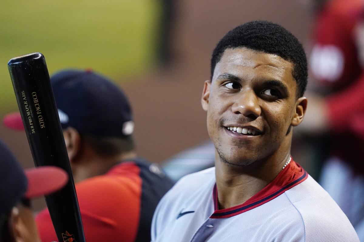 Washington Nationals star Juan Soto stands in the dugout during a game.