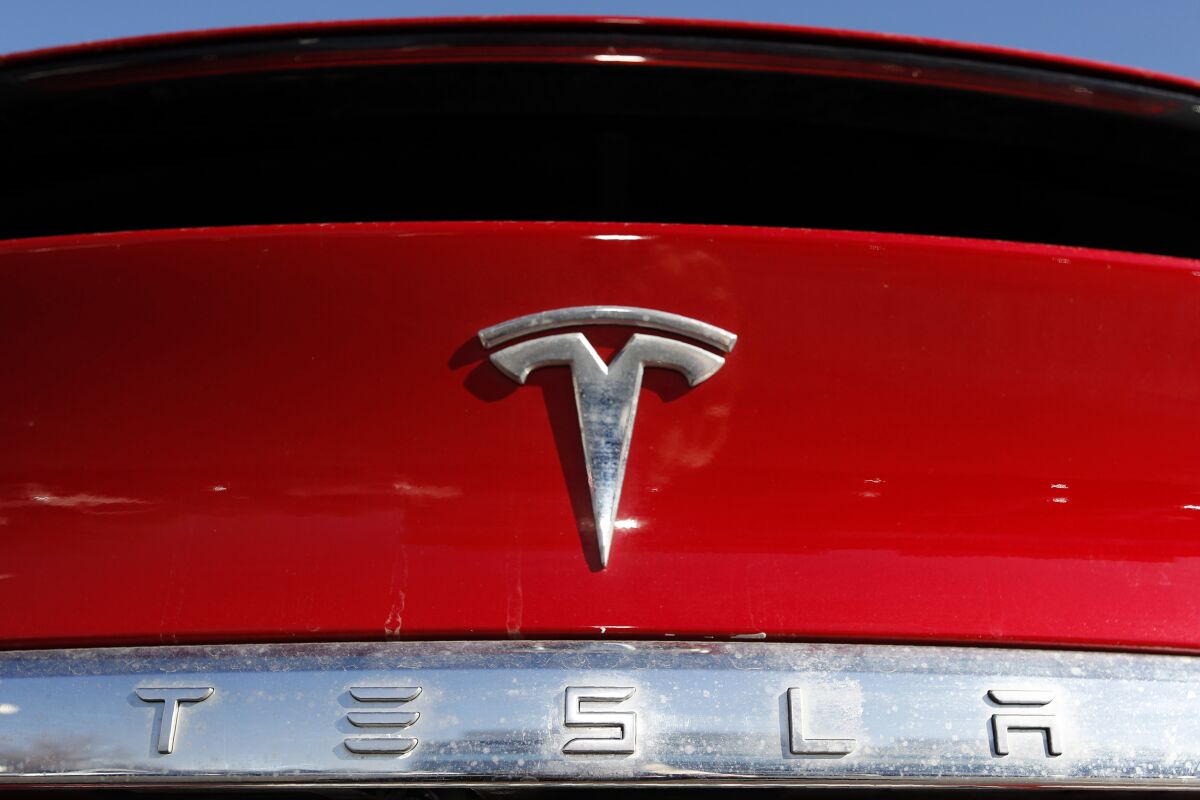 FILE - In this Feb. 2, 2020, file photo, the company logo appears on an unsold 2020 Model X at a Tesla dealership in Littleton, Colo. Tesla reported Wednesday, April 20, 2022, that its first-quarter net earnings were over seven times greater than a year ago, powered by strong sales despite global supply chain kinks and pandemic-related production cuts in China. (AP Photo/David Zalubowski, File)