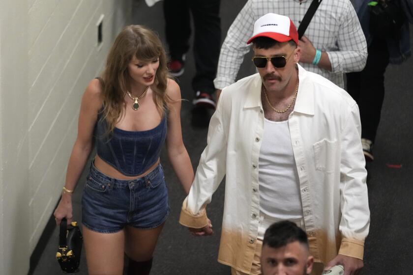 Travis Kelce, tight end de los Chiefs de Kansas City, y su novia, la superestrella pop Taylor Swift, salen tomados de la mano tras un partido de la NFL ante los Ravens de Baltimore, el jueves 5 de septiembre de 2024 (AP Foto/Ed Zurga)