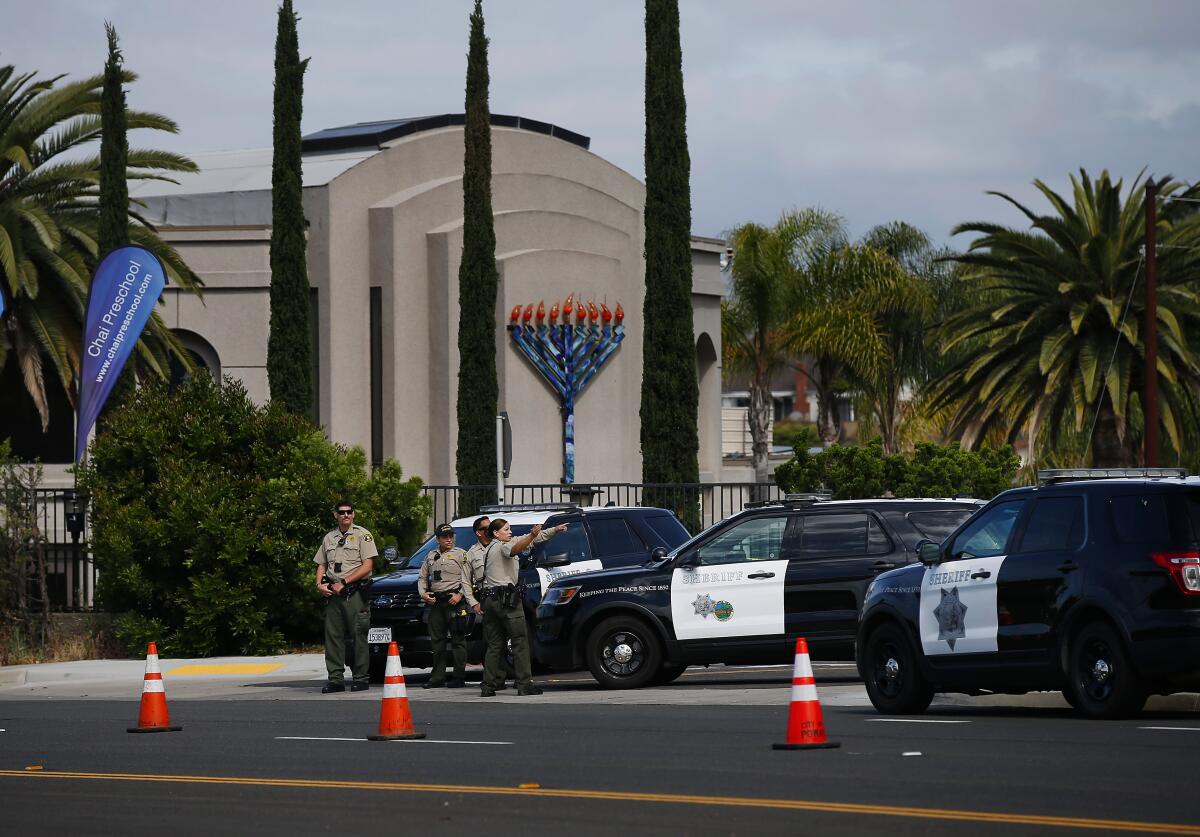 Sheriff’s deputies stand near a street outside a synagogue. 