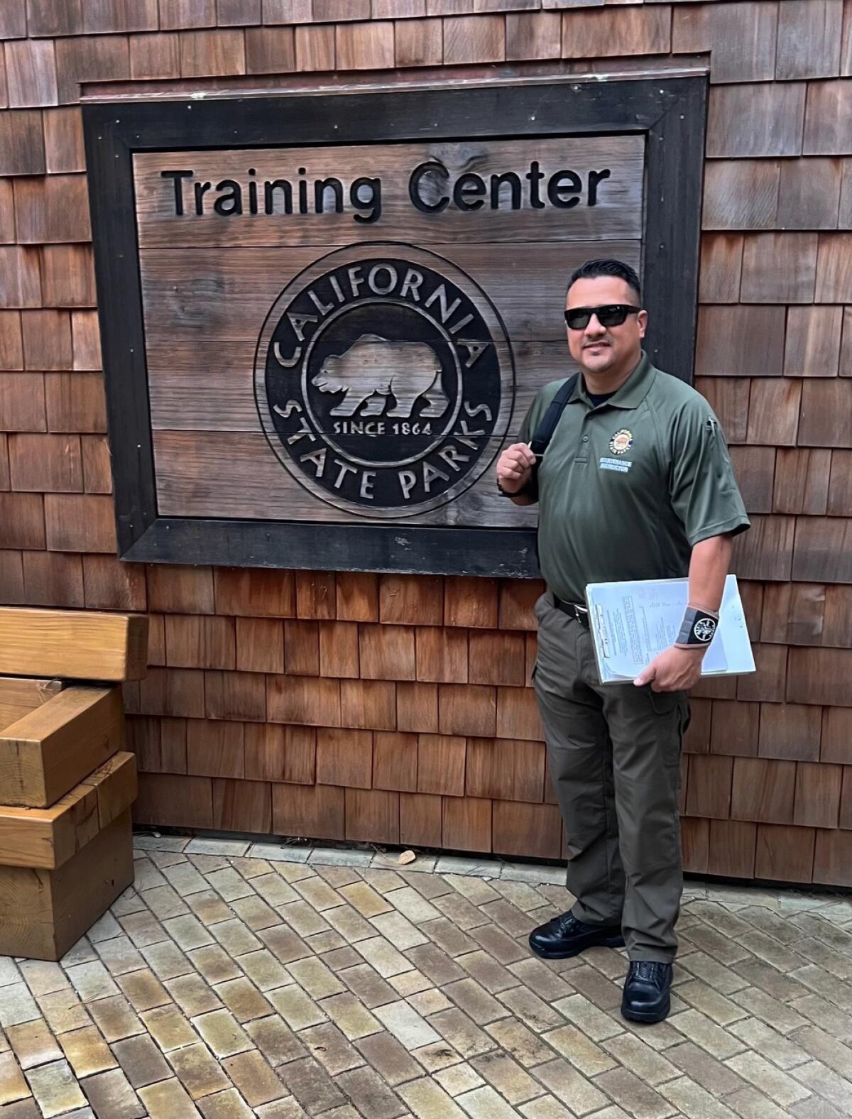 A man standing in front of California State Parks training center sign