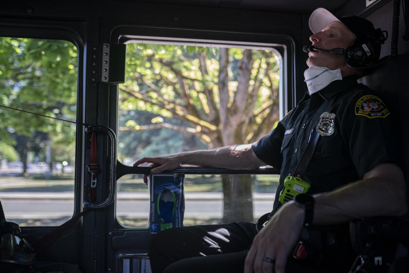 Salem Fire Department paramedic Justin Jones tries to stay cool after responding to a heat exposure call during a heat wave, Saturday, June 26, 2021, in Salem, Ore. (AP Photo/Nathan Howard)