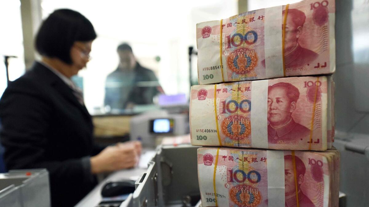 An employee counts money at a bank in Lianyungang, in eastern China's Jiangsu province. In the event of a trade war with the United States, China could resort to devaluing its currency.