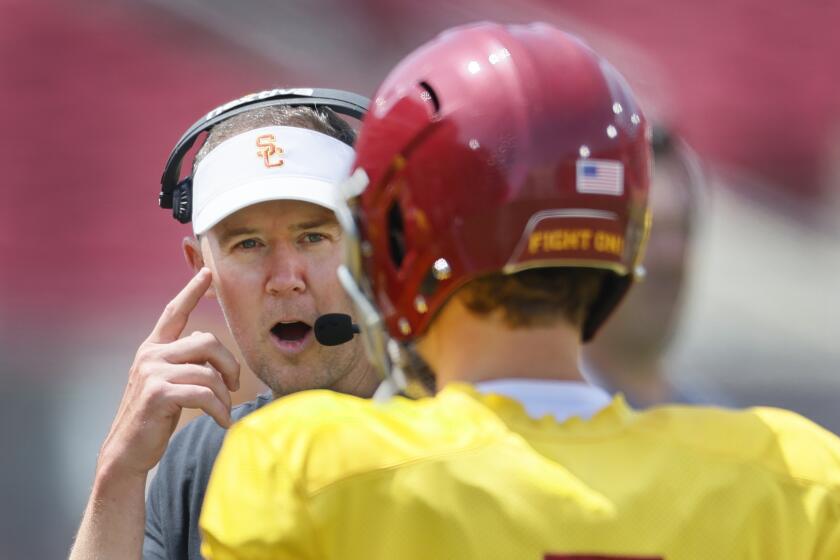 USC coach Lincoln Riley points to his head as he talks with quarterback Miller Moss during the USC spring game 