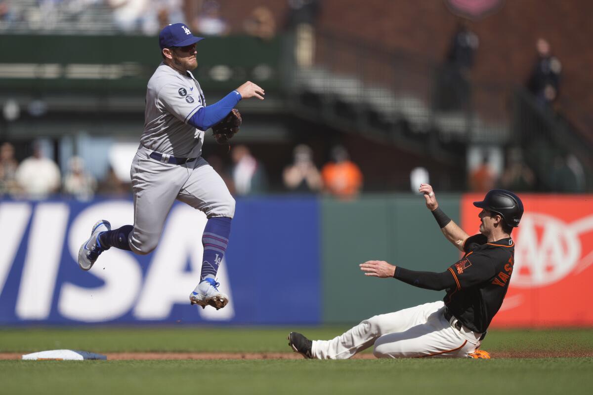 Dodgers second baseman Max Muncy, left, turns a double play after forcing out San Francisco's Mike Yastrzemski.