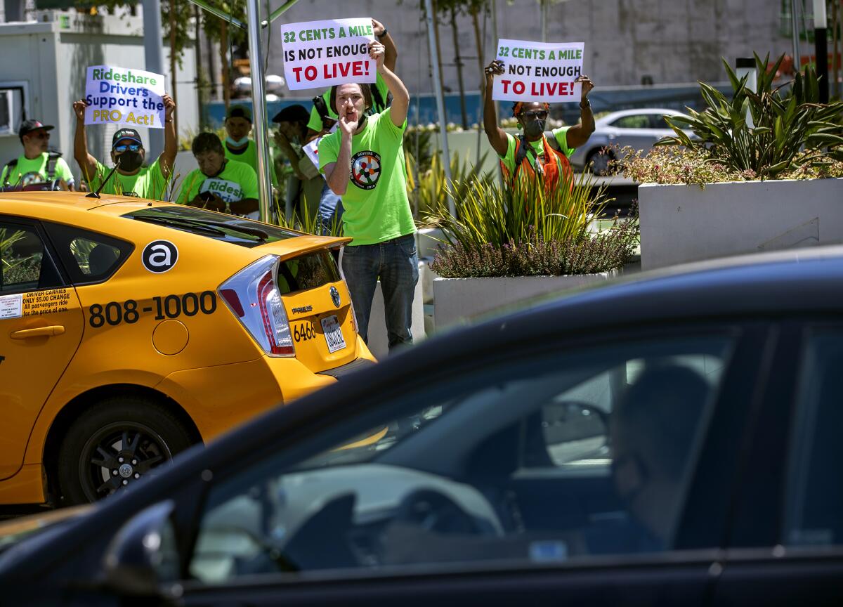 Protesting rideshare drivers try to get the attention of a rideshare driver arriving at LAXit