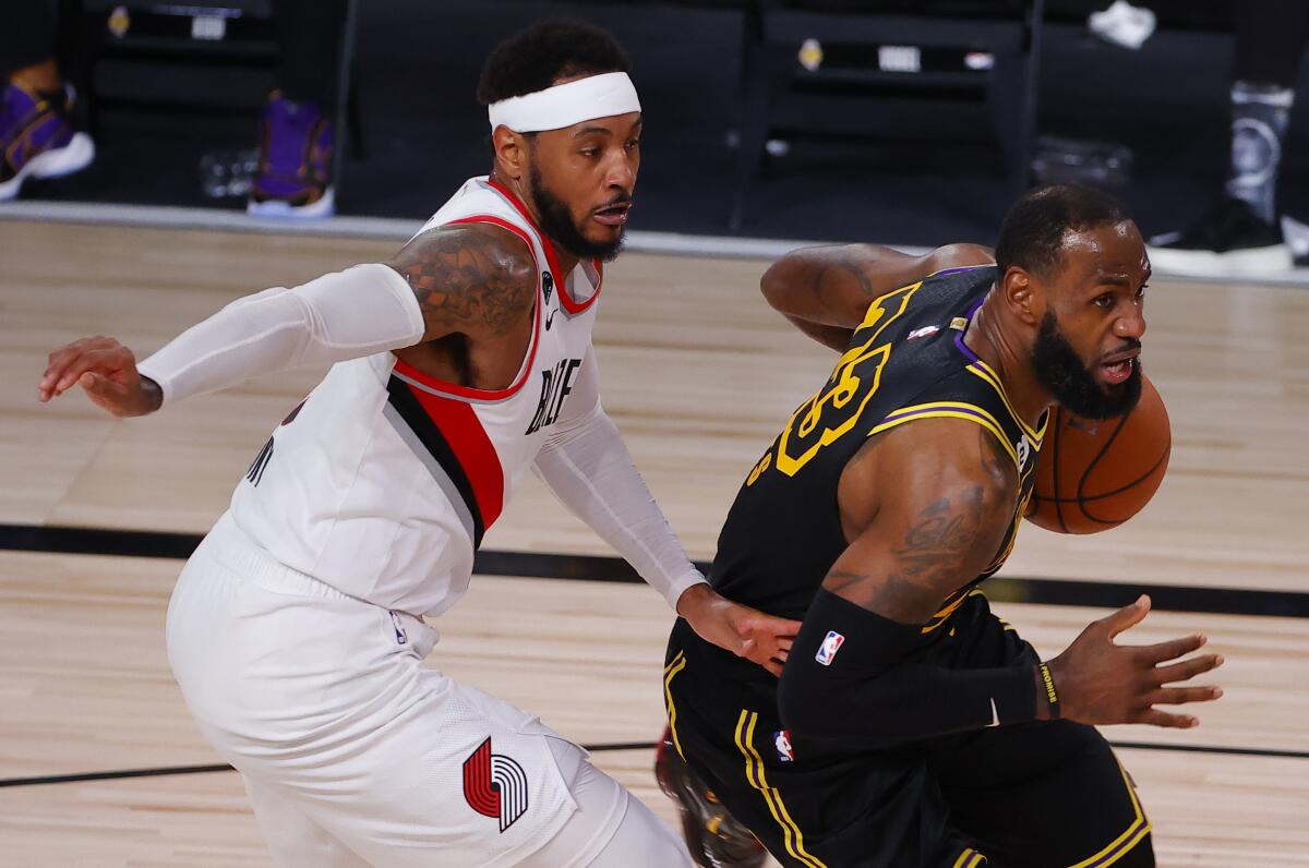 El jugador de los Lakers de Los Ángeles LeBron James (derecha), conduce la pelota ante su rival de los Trail Blazers.