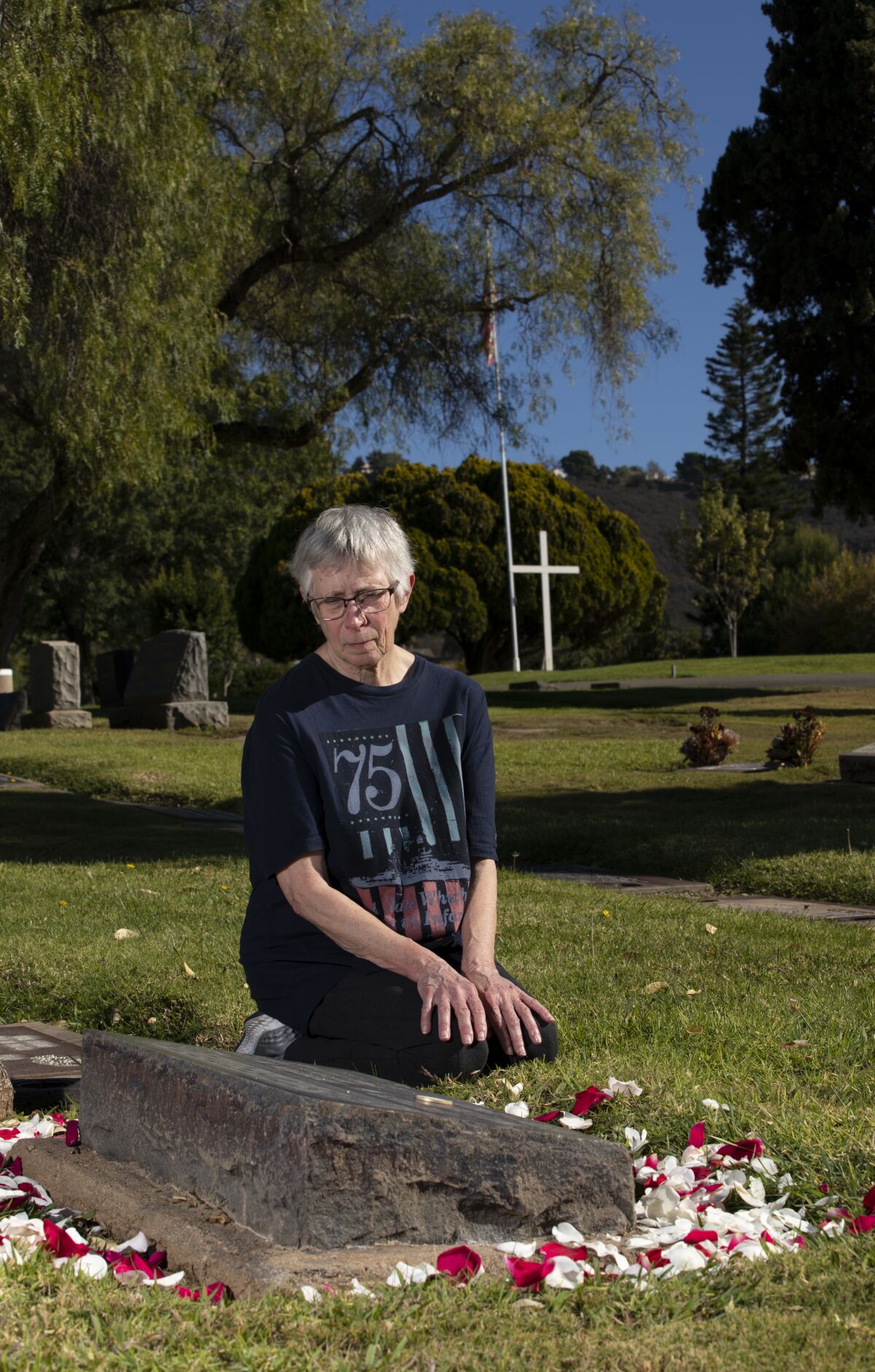 Linda Dudik at the grave of Seaman 2nd Class Gordon Stafford at the in San Marcos Cemetery.