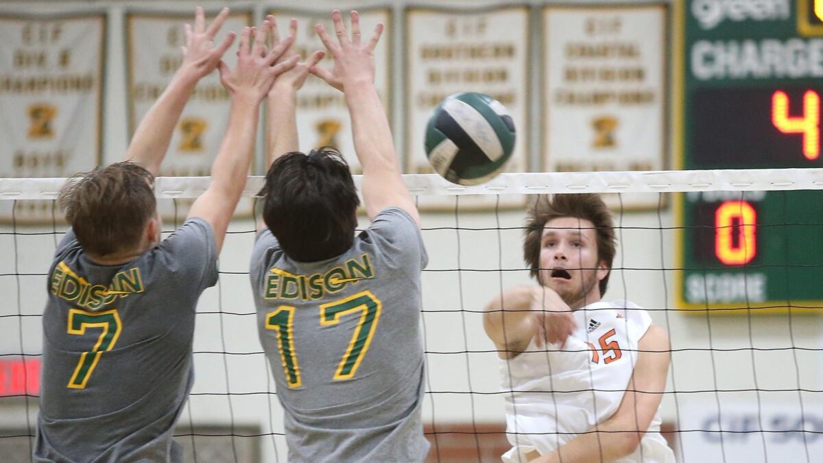 Huntington Beach High's Ryan Bevington hits past Edison's James Carpenter (7) and Trevor McCay (17) during pool-play action at the Orange County Championships on Friday.