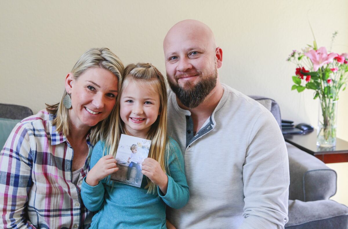 Promoting random acts of kindness in memory of their late son Blake, seen in picture, Leah Davis, left, and Rob Davis, right, and their daughter Scarlett, 5, pose for a photo in their Carmel Valley home on Jan. 7. Over the past 2-1/2 years, hundreds of people worldwide have posted on social media their good deeds #ForBlake.