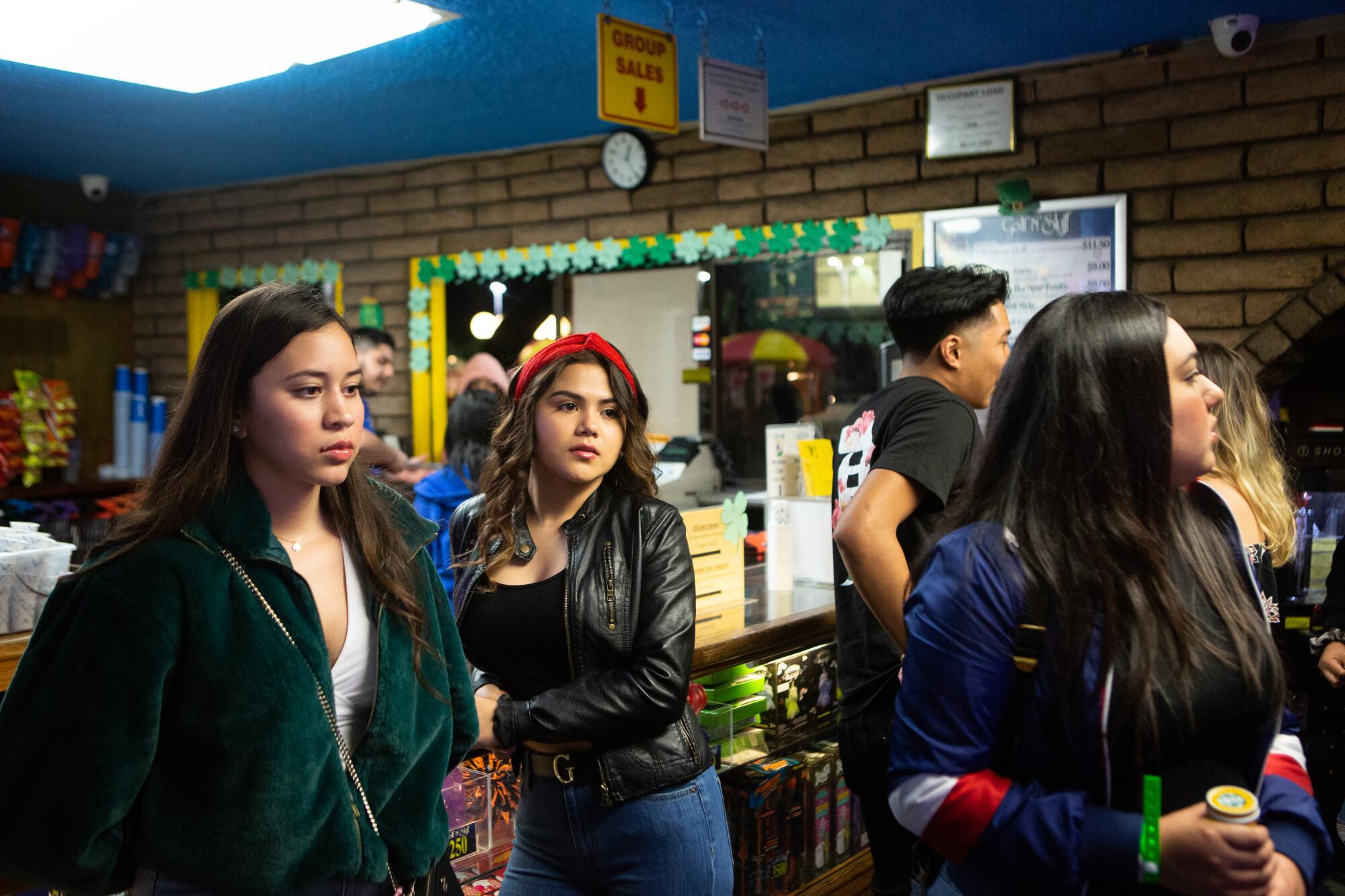 Dalia Hurtado, center, waits in line for miniature golf in Norwalk.