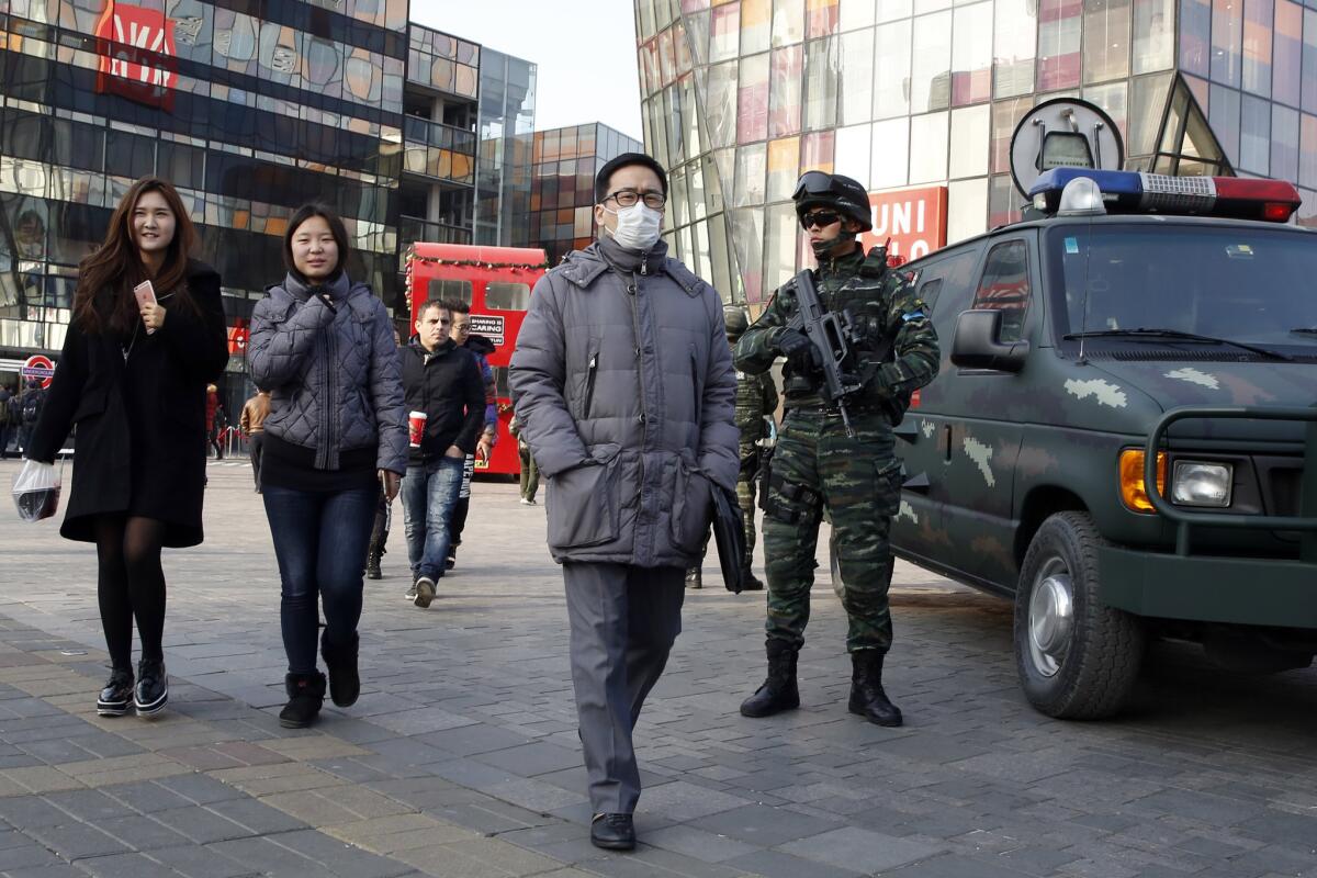 Heavily armed Chinese paramilitary police guard a popular mall in the Sanlitun district of Beijing on Thursday.