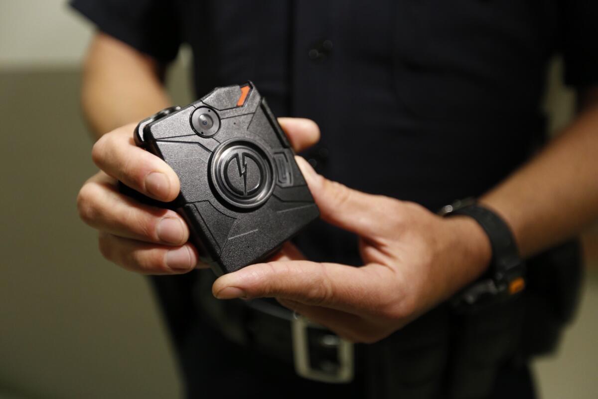 A Los Angeles police officers demonstrates how body cameras work in August 2015. Cameras in four LAPD divisions captured nearly 255,000 videos between August and December 2015, according to a new report from the department. (Al Seib / Los Angeles Times)