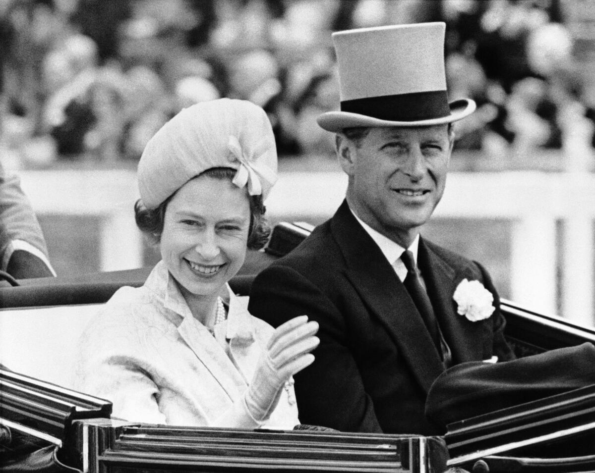 FILE - In this June 19, 1962 file photo, Britain's Queen Elizabeth II and Prince Philip travel by open carriage around the track prior to the race program, at Ascot, England. Prince Philip was the longest serving royal consort in British history. In Britain, the husband or wife of the monarch is known as consort, a position that carries immense prestige but has no constitutional role. (AP Photo/File)
