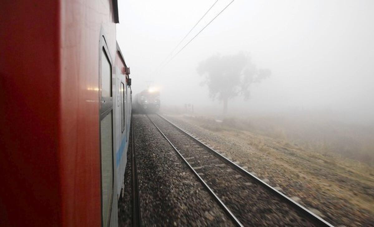Trains pass in the fog outside Allahabad, India.