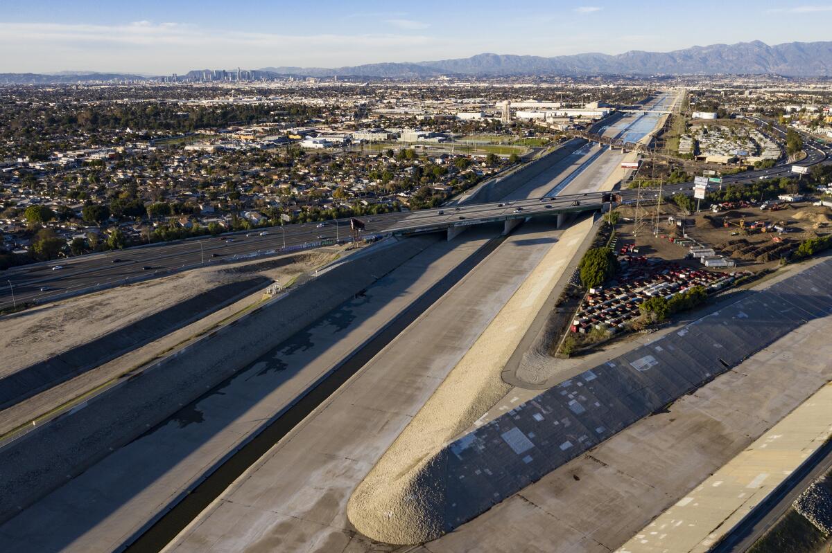 Aerial view of concrete-sided confluence of the Los Angeles River and Rio Honda, with downtown L.A. in the background.  