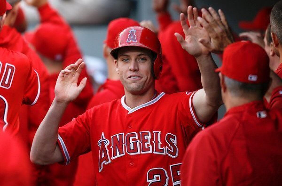 Angels speedster Peter Bourjos is congratulated by teammates after scoring on a sacrifice fly by Albert Pujols in the first inning of a game against the Seattle Mariners at Safeco Field.