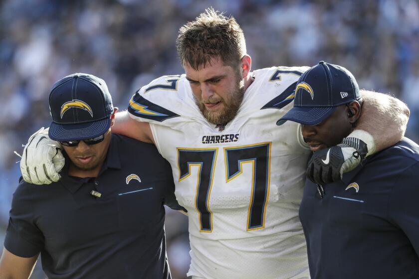 NASHVILLE, TN, SUNDAY, OCTOBER 20, 2019 - Los Angeles Chargers offensive guard Forrest Lamp (77) is helped off the field after getting hurt against the Titans at Nissan Stadium. (Robert Gauthier/Los Angeles Times)