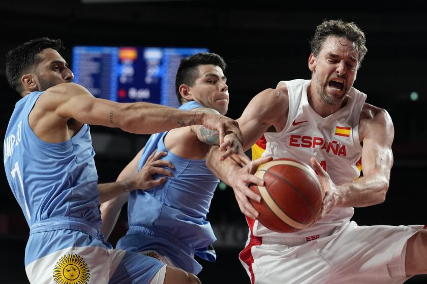 Spain's Pau Gasol, right, fights for a rebound with Argentina's Facundo Campazzo, left, and Gabriel Deck.