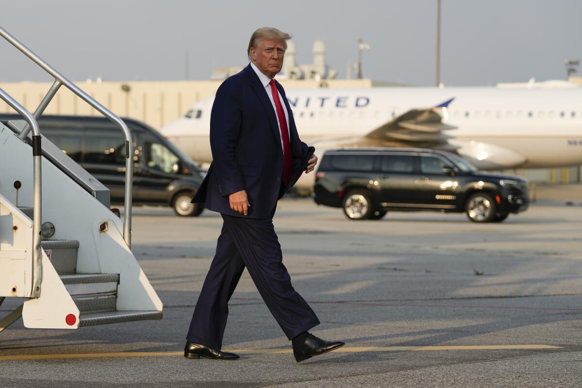 Donald Trump walking past a plane 