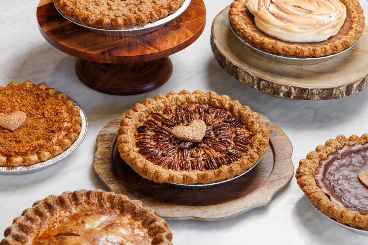 A spread of holiday pies from Friends & Family. At center is a pecan pie with a pastry heart in its middle.