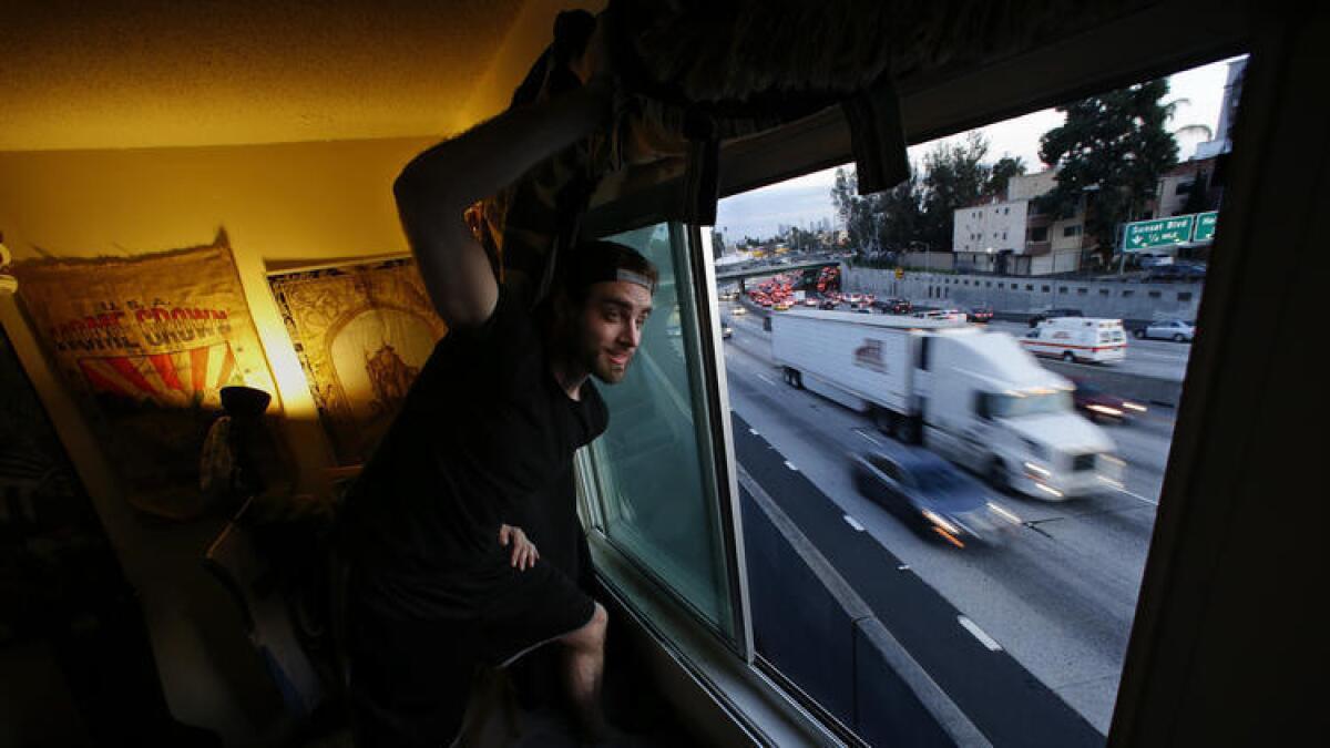 Mason Miller looks out of his bedroom window that overlooks the northbound lanes of the 101 Freeway in Hollywood.