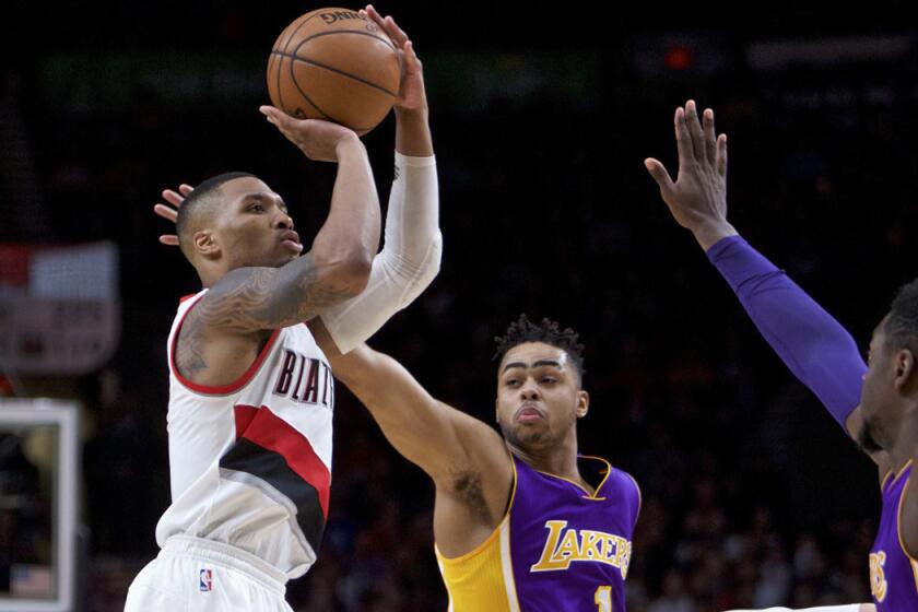 Portland Trail Blazers guard Damian Lillard, left, shoots over Lakers guard D'Angelo Russell, center, and forward Julius Randle during the second half on Jan. 5.