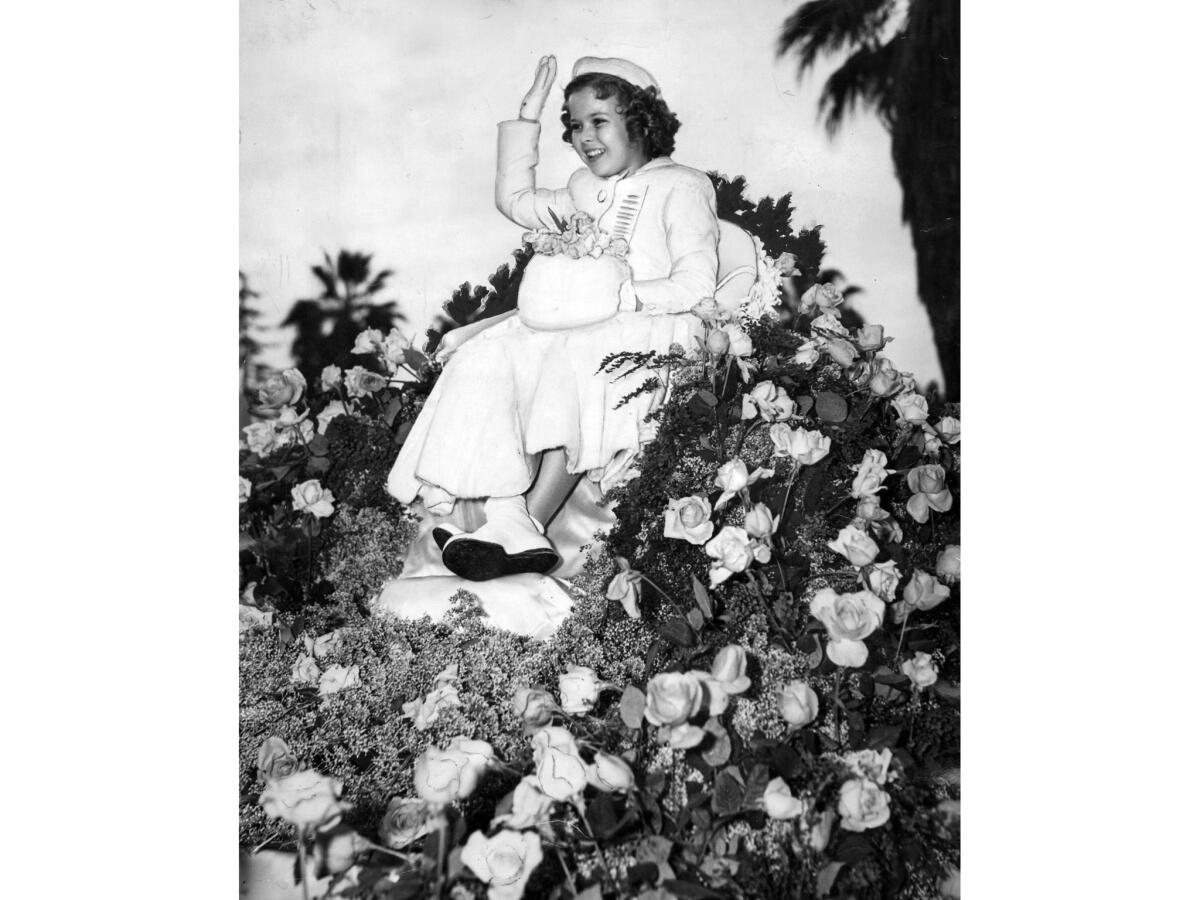 Jan. 2, 1939: Rose Parade grand marshal Shirley Temple rides on a float covered with a bed of roses.