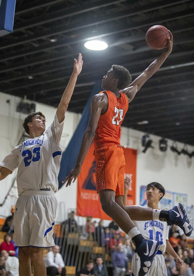 Pacifica Christian Orange County's Judah Brown dunks over St. Michael's Prep's Ben Sturkie's during a nonleague game on Tuesday, November 13.