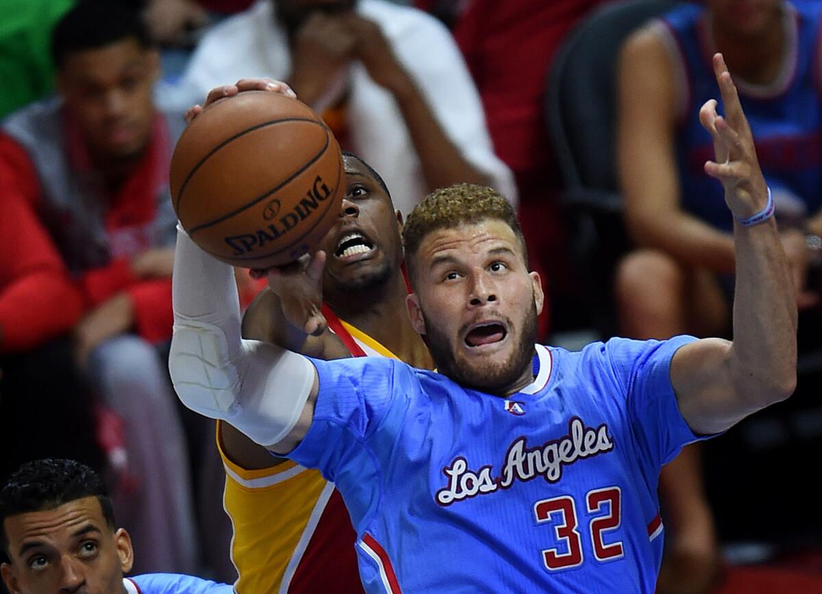 Clippers power forward Blake Griffin, in his first game back from injury, grabs a rebound in front of Rockets forward Terrence Jones.