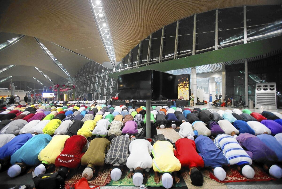 Muslim men offer prayers at Kuala Lumpur International Airport for missing Malaysia Airlines Flight 370.