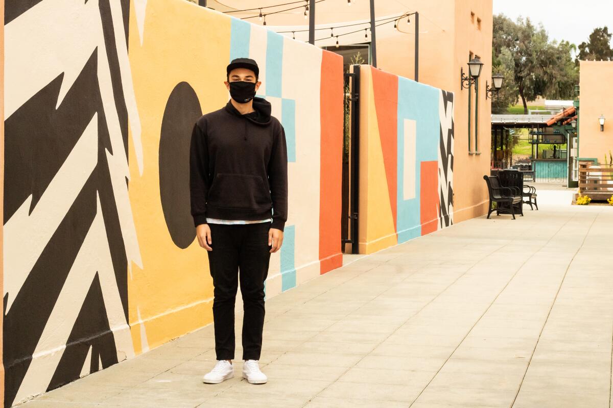 Artist James Armenta stands in front of his untitled mural for Liberty Station's "Installations at the Station."