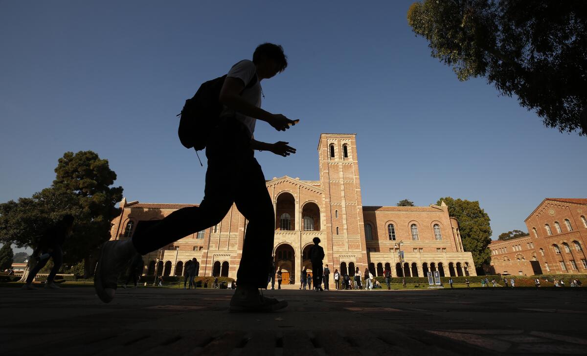 A student walks near Royce Hall on the campus of UCLA.