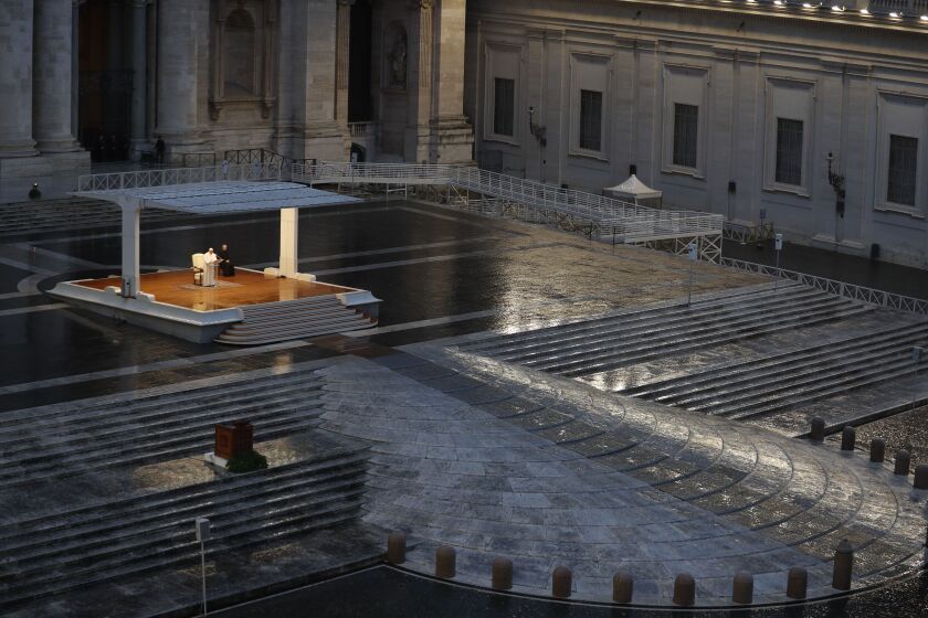 FILE - In this photo taken on March 27, 2020, Pope Francis, white figure standing alone at center, delivers an Urbi et orbi prayer from the empty St. Peter's Square, at the Vatican. If ever there was a defining moment of Pope Francis during the coronavirus pandemic, it came on March 27, the day Italy recorded its single biggest daily jump in fatalities. From the rain-slicked promenade of St. Peter’s Basilica, Francis said the virus had shown that we’re all in this together, that we need each other and need to reassess our priorities. (Yara Nardi/Pool Photo via AP )