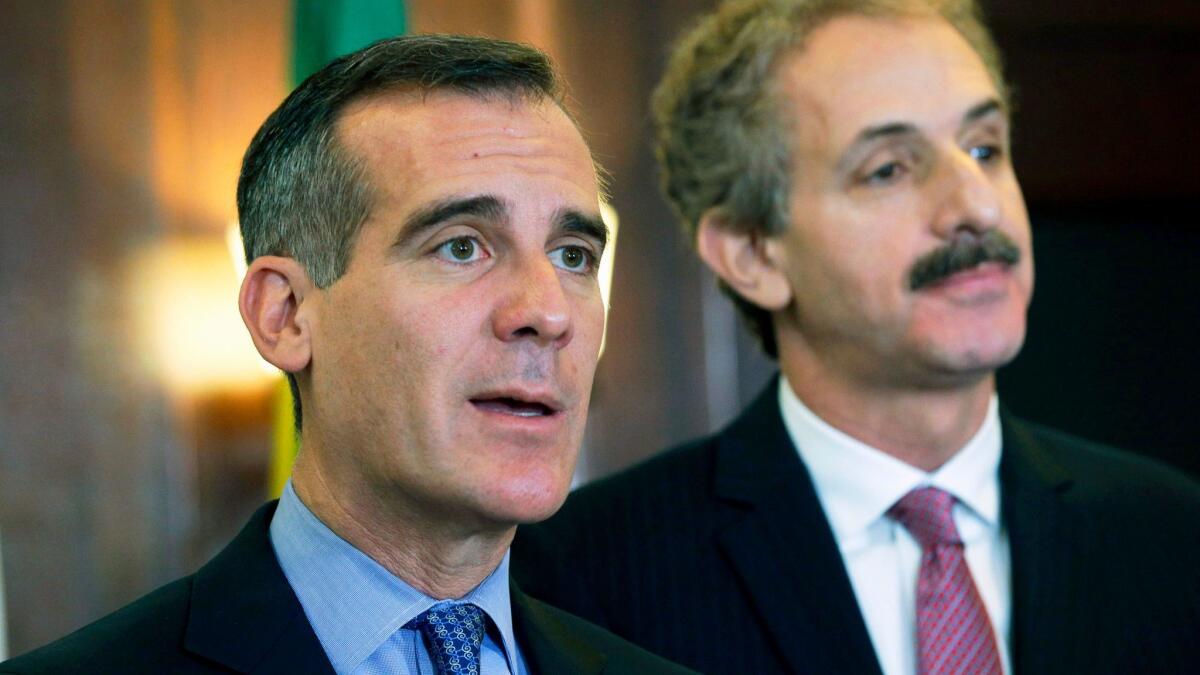 Los Angeles Mayor Eric Garcetti, left, and City Atty. Mike Feuer announce the creation of a $10-million fund to provide legal assistance to immigrants facing removal proceedings at a City Hall news conference in December.