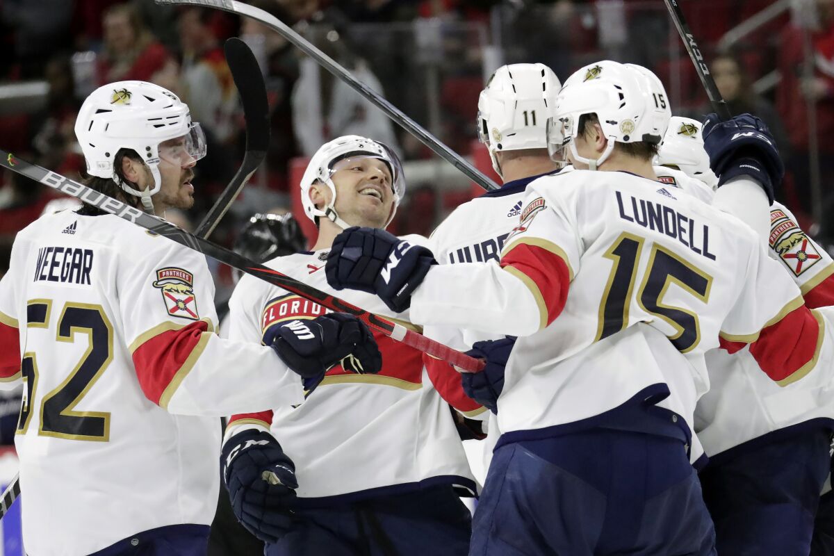 Florida Panthers center Sam Reinhart, second from left, celebrates his game tying goal with teammates during the third period of an NHL hockey game against the Carolina Hurricanes Wednesday, Feb. 16, 2022, in Raleigh, N.C. (AP Photo/Chris Seward)