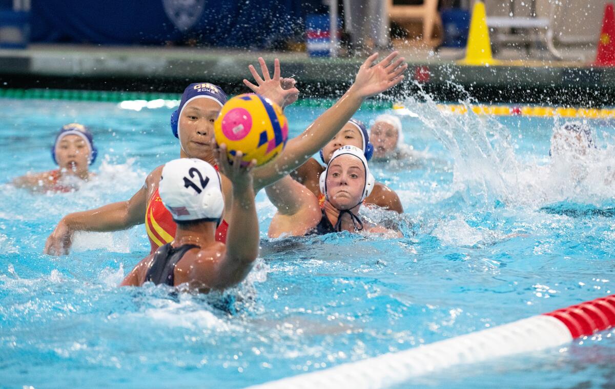 Emily Ausmus prepares to pass while while teammate Ava Johnson battles for position against Team China on Monday.