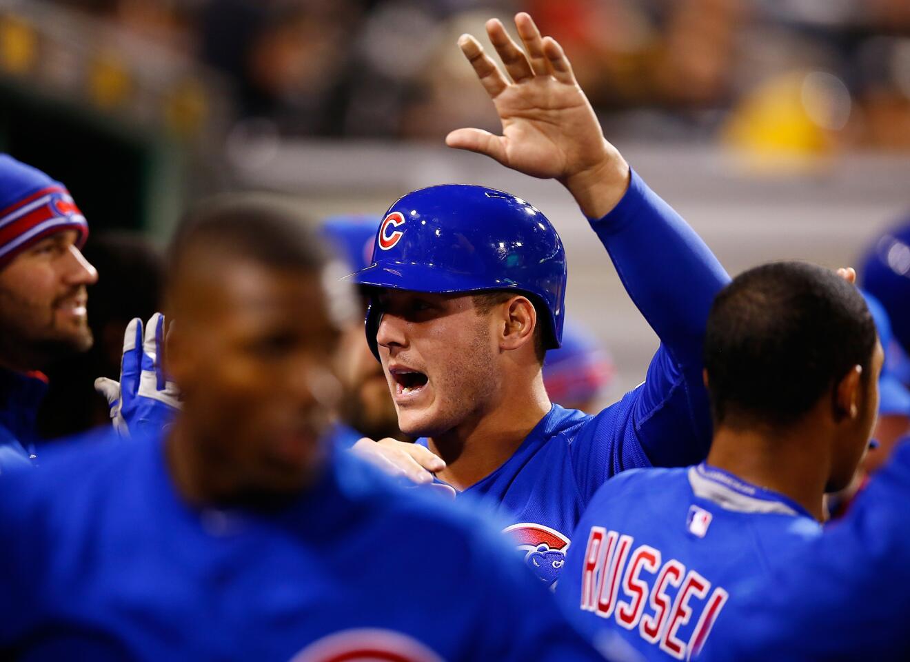 Anthony Rizzo celebrates with teammates in the dugout after scoring the game-tying run in the ninth inning.