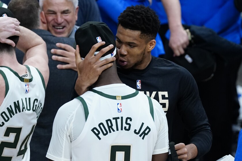 Milwaukee Bucks forward Giannis Antetokounmpo embraces Bobby Portis (9) after the Bucks defeated the Atlanta Hawks in Game 6 of the Eastern Conference finals in the NBA basketball playoffs, advancing to the NBA Finals, Saturday, July 3, 2021, in Atlanta. (AP Photo/John Bazemore)