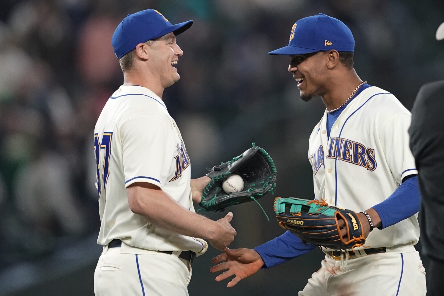 Seattle Mariners closing pitcher Paul Sewald, left, is greeted by Julio Rodriguez, right, after a baseball game against the Oakland Athletics, Sunday, July 3, 2022, in Seattle. (AP Photo/Ted S. Warren)