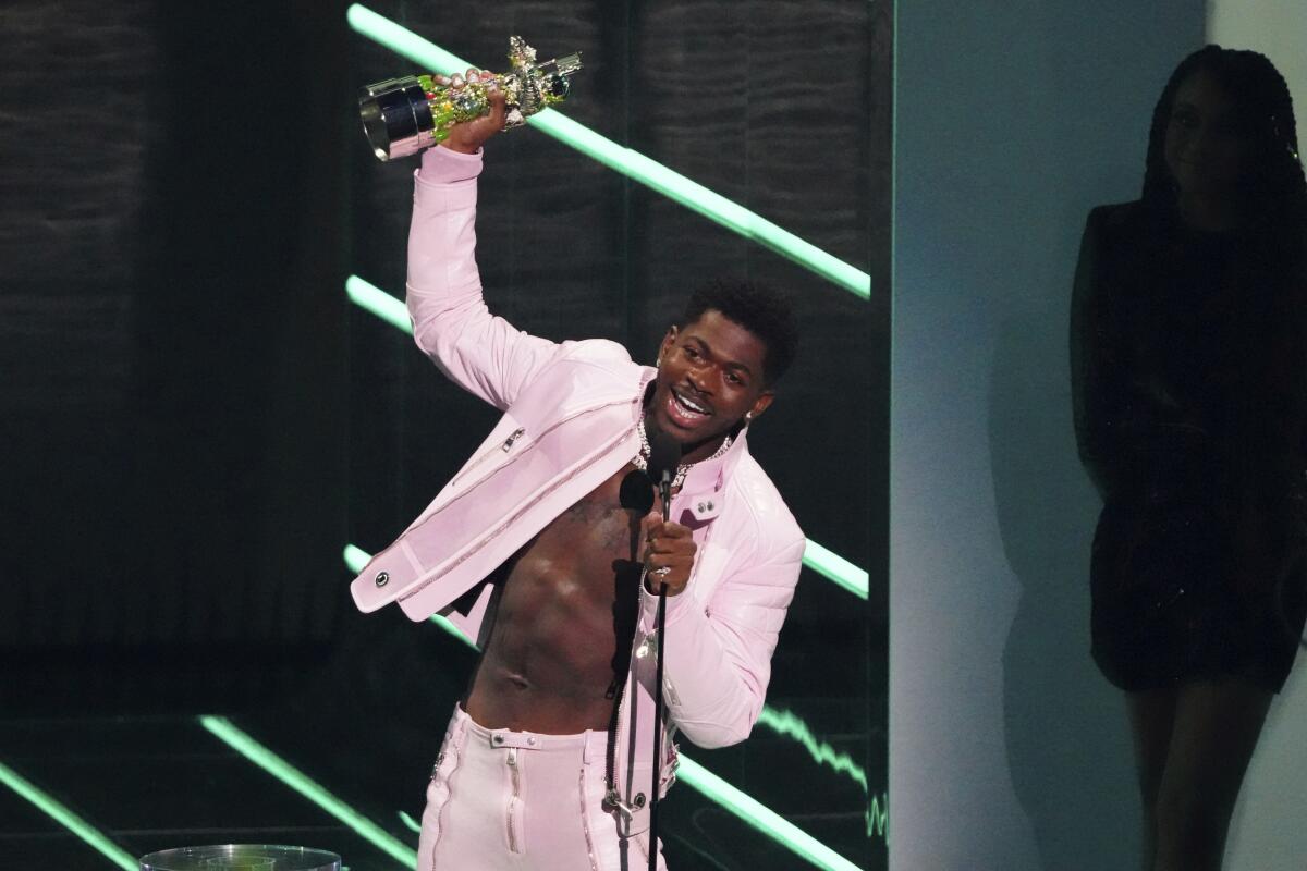 Lil Nas X holds up his award for video of the year and speaks into a microphone