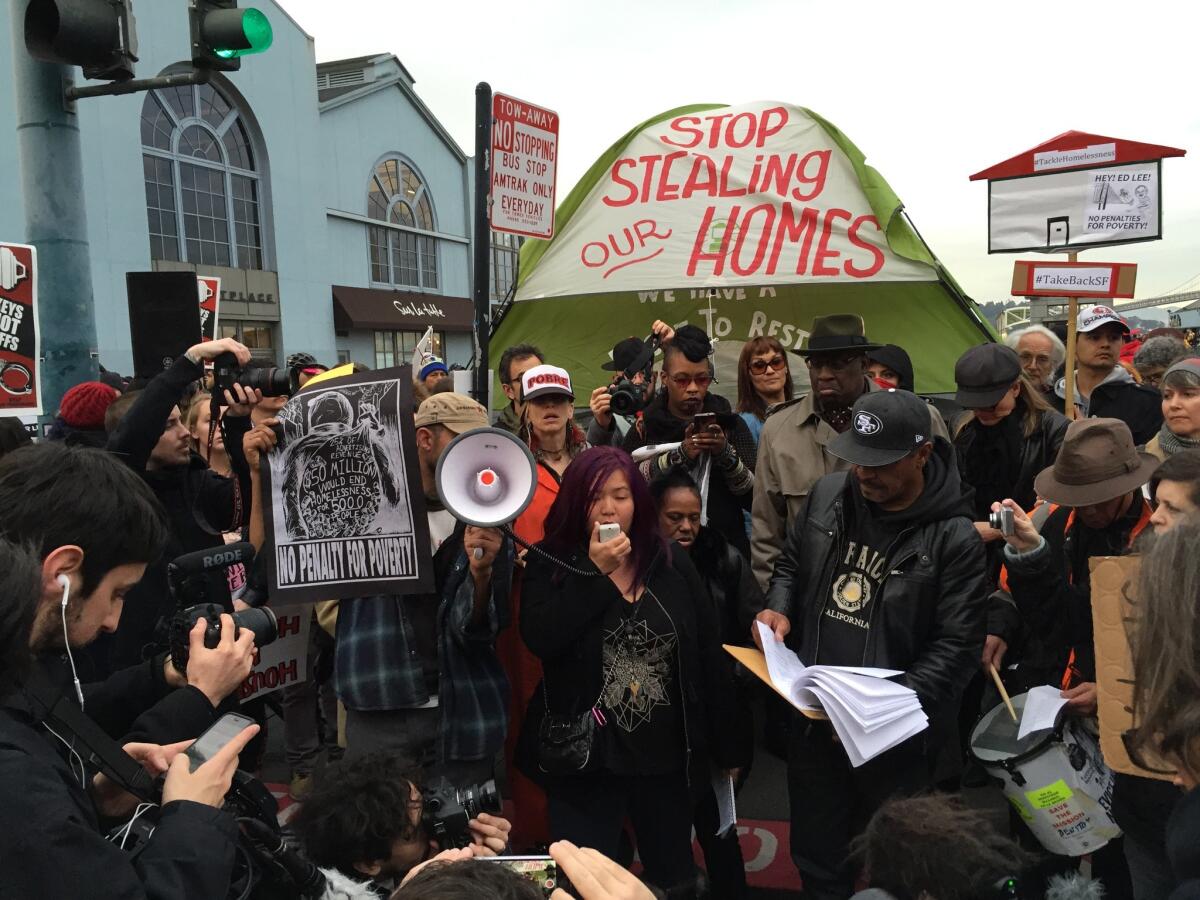 Julianna Cheng, 29, center, speaks at a rally at San Francisco's Embarcadero protesting the removal of homeless people to make way for Super Bowl 50 revelers.