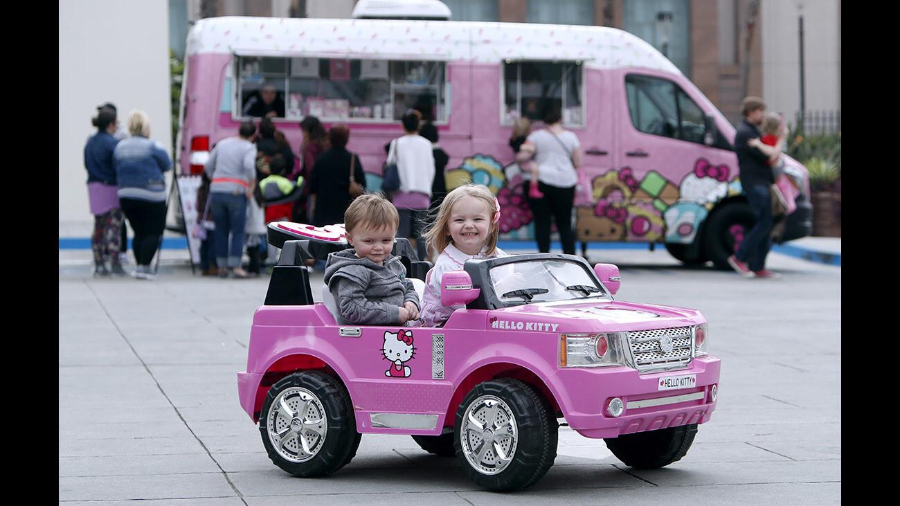 As customers like their parents wait in line to buy merchandise from the Hello Kitty Cafe truck, Naomi Richards, 3, of Burbank, and her one-year old brother Westley, ride on a Hello Kitty toy SUV, at the old Ikea parking lot on 600 block of N. San Fernando Rd., in Burbank on Saturday, Feb. 10, 2018. Item prices ranged from a $3 small bow-shaped bottle of water to $36 32 oz. stainless steel thermal bottles and $27 t-shirts.