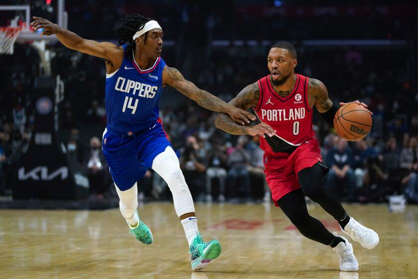 Los Angeles Clippers guard Terance Mann (14) defends against Portland Trail Blazers guard Damian Lillard (0) 