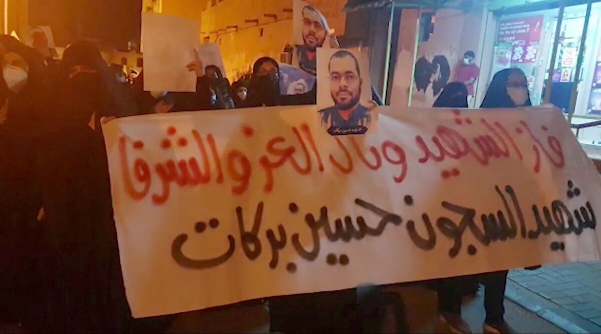 In this image made from video provided by the Bahrain Institute for Rights and Democracy, demonstrators march to protest the death of a prisoner in Diah, Bahrain, Wednesday, June 9, 2021. Hundreds on Wednesday held a rare protest in Bahrain over the death of a vaccinated prisoner from the coronavirus held by the island kingdom. The banner in Arabic reads: "The liberated and honorable martyr has prevailed, the martyr prisoner Husain Barakat." (Bahrain Institute for Rights and Democracy via AP)