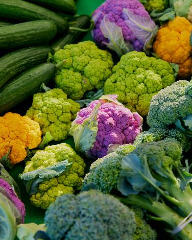 Broccoli and green, orange and purple cauliflower at a farmers market