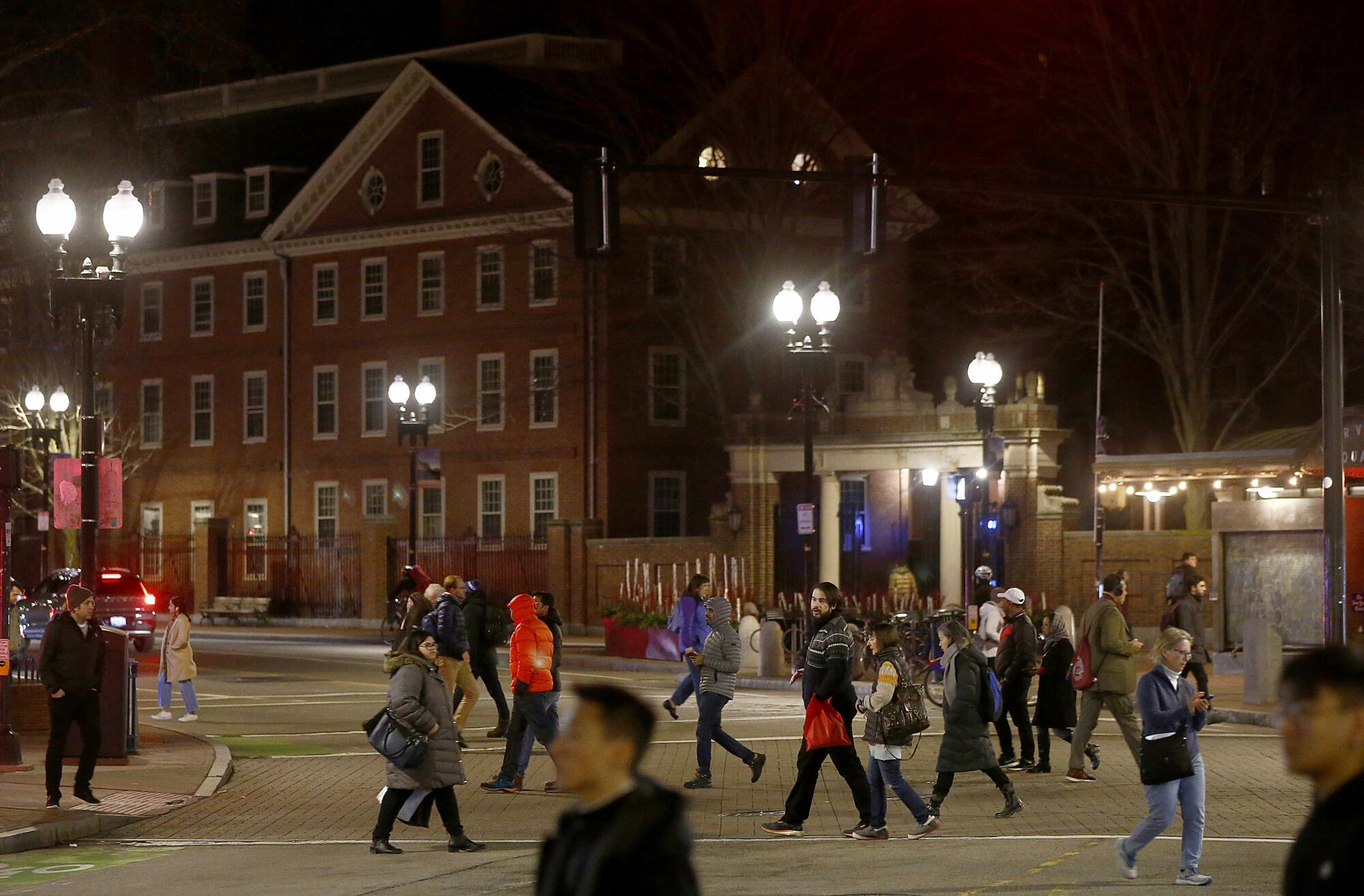 Pedestrians cross Brattle Street in Harvard Square, where several buildings are scheduled for demolition to make way for new development.