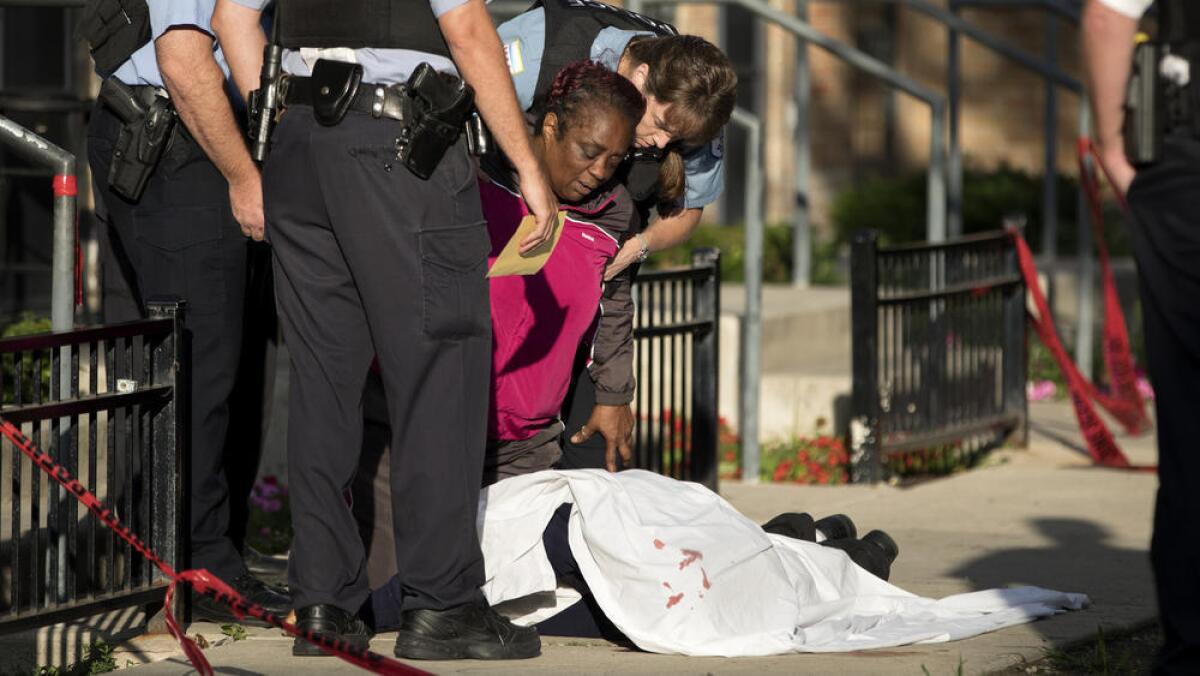 Una mujer llora sobre el cuerpo de su hijo, una de las más recientes víctimas de la violencia armada en Chicago (Erin Hooley / Chicago Tribune).