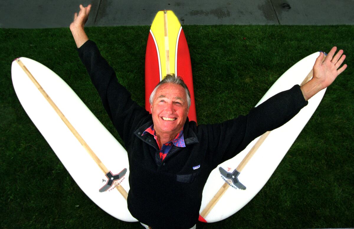 Tom Morey poses with the Swizzle, one of the surfboards he invented. 